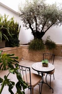 a patio with a table and chairs and a tree at Hotel Puerta del Mar - Adults Recommended in Nerja