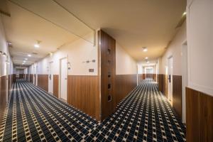 un corridoio vuoto con porte in legno e pavimento in piastrelle di Xiamen Evening Breeze Hotel a Xiamen