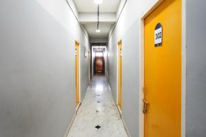an empty corridor in an office building with a yellow door at Hotel O Aryan Home Stay in Dehradun