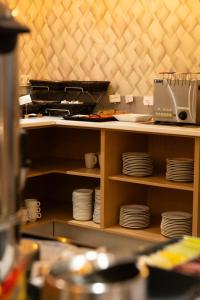 a kitchen with a shelf with plates on it at Hotel Puerta del Mar - Adults Recommended in Nerja