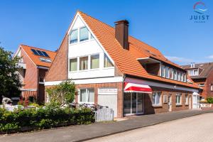 a house with an orange roof on a street at Haus Insa 145 - Ferienwohnung elf in Juist