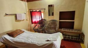 a room with a bed and two chairs in it at Agnihotri Tourism Centre in Machhrehta