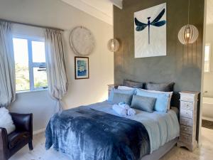a bedroom with a bed with two stuffed animals on it at The Blue Dragonfly in Jeffreys Bay