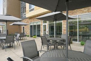 un patio extérieur avec tables, chaises et parasols dans l'établissement Fairfield by Marriott Niagara Falls, à Niagara Falls