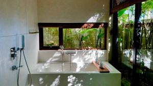 Un baño con bañera y ventana. en Nongnia Beach Villa, en Tân Thành (1) 63 fotos más