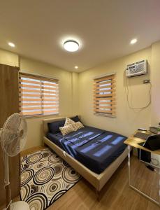 una camera con letto, scrivania e ventilatore di Casa Corazon - Pineview Heights - Amadeo Tagaytay a Dagatan
