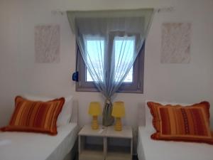 a living room with two beds and a window at Villa Jodi Hilltop in Pitsidia