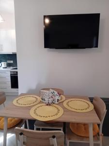 a dining room table with chairs and a television at Villa Jodi Hilltop in Pitsidia