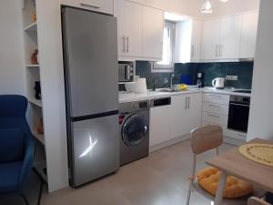 a kitchen with a refrigerator and a washing machine at Villa Jodi Hilltop in Pitsidia