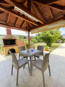 a patio with a table and chairs and a fireplace at Themis Rooms in Nea Vrasna