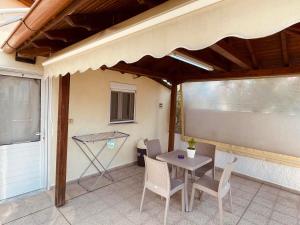a patio with a table and chairs and a window at Themis Rooms in Nea Vrasna +35 photos