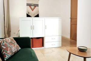 a living room with a green couch and a white cabinet at Studio indépendant tout confort in Pujaut