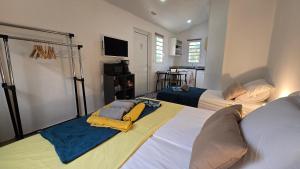 une chambre d'hôtel avec deux lits et une télévision dans l'établissement Tiny House & Tente Lodge, Le Paradis des Petits Voyageurs, au Diamant