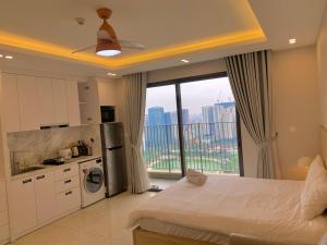 a room with a bed and a kitchen with a window at Vinhomes D'Capitale - Luka homes in Hanoi