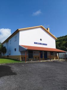 a large white building with a sign on it at Hotel JSF in Horta