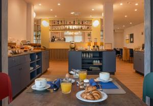eine Küche mit einem Tisch, auf dem Frühstücksspeisen stehen in der Unterkunft Hotel Harmony-Smile in Lido di Camaiore
