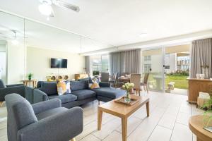 un soggiorno con divani blu e un tavolo di 2 Bedroom Seaview, Holiday Apartment, Lagoon Beach a Città del Capo