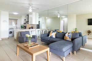 un soggiorno con due divani blu e un tavolo di 2 Bedroom Seaview, Holiday Apartment, Lagoon Beach a Città del Capo