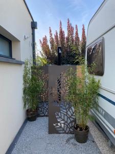 a group of plants in pots next to a building at La Croisée, Caravane avec toilette et lavabo - particulier in Guéreins +1 photo