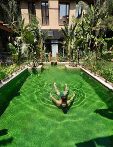 a person swimming in a pool of green water at Saman Hotel Boutique in Valencia