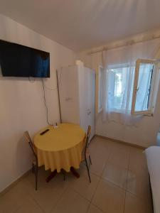 a small dining room with a table and a television at Apatmani Darija in Komiža
