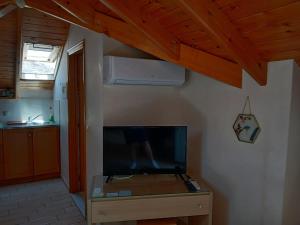 a living room with a tv and a wooden ceiling at Kritikos Rooms in Monemvasia