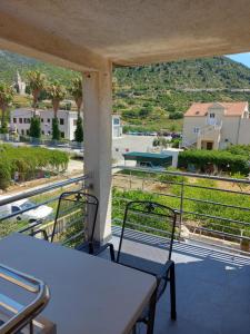 a balcony with a table and chairs and a view at Apatmani Darija in Komiža