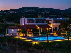 a large house with a swimming pool at night at Tearida Hotel and Suites in Samothraki