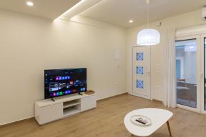 a white living room with a flat screen tv at Elea in Mytilene