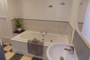 un baño con bañera y lavabo en Mizen Lodge, en Berrynarbor 12 fotos más