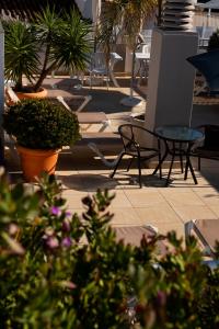 a patio with chairs and tables and potted plants at Hotel Puerta del Mar - Adults Recommended in Nerja