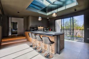 Luxury Villa Orion with heated Pool, Billard في Biéville-Beuville: مطبخ مع منضدة سوداء وكراسي البار