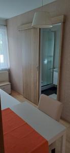 a room with a white table and chairs and a hallway at Seeblick Krippenstein2 in Obertraun