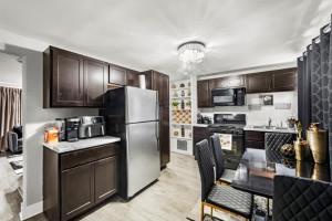 a kitchen with wooden cabinets and a stainless steel refrigerator at Hamaline Luxury Guest House in Chicago