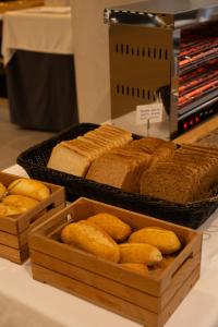 a table topped with wooden boxes filled with bread at Hotel Puerta del Mar - Adults Recommended in Nerja