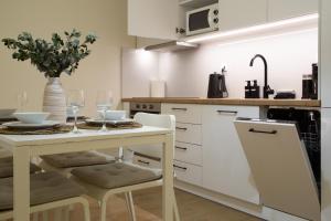a white kitchen with a table and chairs and a sink at Elea in Mytilene +22 photos