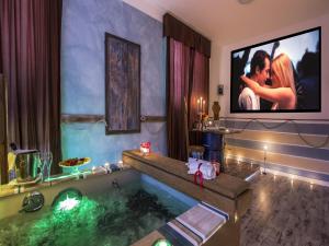 a bathroom with a tub with a tv on the wall at Hotel Butterfly in Torre del Lago Puccini