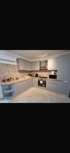 a large kitchen with white cabinets and appliances at San Miniato 2-Bed Villa Sleeps 6 with Parking in San Romano