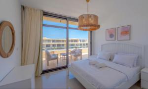 a bedroom with a bed and a balcony with a table at Luxury Apartments in G-Cribs El Gouna in El Gouna