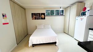 a small room with a bed and a refrigerator at Requinte pertinho do mar da Atalaia in Santa Maria +25 photos