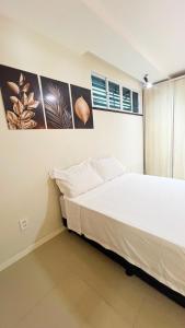 a bedroom with a bed and some pictures on the wall at Requinte pertinho do mar da Atalaia in Santa Maria
