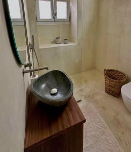 a bathroom with a black sink on a wooden counter at Alemarni Syros in Ermoupoli