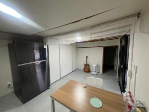 a kitchen with a refrigerator and a table in a room at Hupori Bagkol Minbak in Uljin