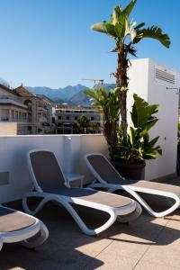 a couple of chairs sitting on a balcony at Hotel Puerta del Mar - Adults Recommended in Nerja