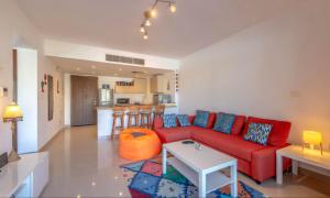 a living room with a red couch and a table at G-Cribs El Gouna - Apartments with Pool Access in El Gouna