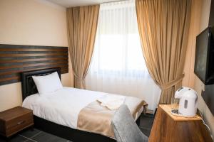 a hotel room with a bed and a television at Hotel Santa Ria in Kŭrdzhali