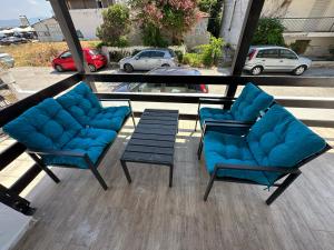 two blue chairs and a coffee table on a porch at Thea Thermaikou in Agia Triada