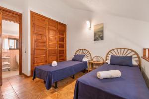 a room with two beds with blue sheets at La Casita de Arise in Playa de las Americas +18 photos