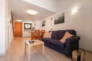 a living room with a blue couch and a table at La Casita de Arise in Playa de las Americas