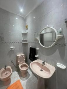 a bathroom with a sink and a toilet and a mirror at Appartement Najma in Tangier